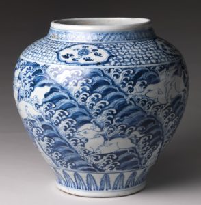 Ming dynasty porcelain jar, blue images of waves and animals on a white background. The decoration is very intricate and delicate. 